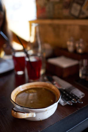 antique ceramic soup plate on wooden table with spoonsの写真素材