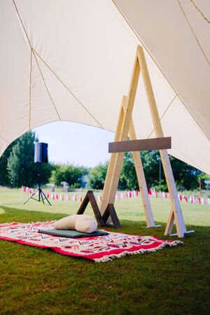 white tent for meditation in the fresh air, a rug and a pillow in nature in the park. Russia, Kazan