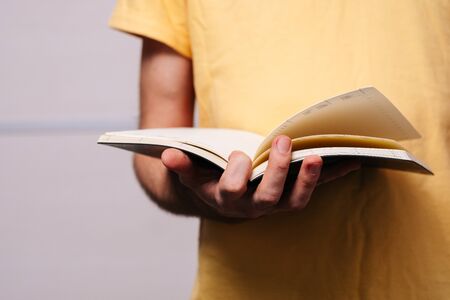 Student holding many books in hands on the background of bookshelves.の写真素材