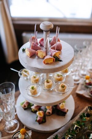 Glasses with seafood snacks and meat on banquet table, close upの写真素材