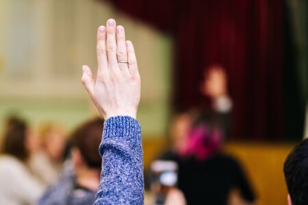 a man raises his right hand in a meeting. Voting. Close upの写真素材