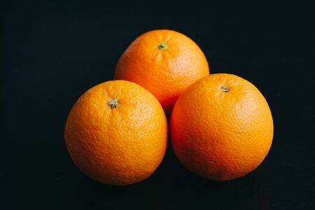 horizontal poster photo of an orange on a black background with light comingの写真素材