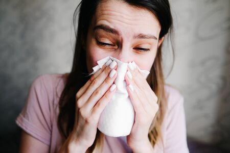 Cough in tissue covering nose and mouth when coughing as COVID-19の写真素材