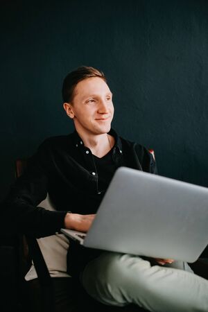 Handsome young man using laptop computer at home.の写真素材