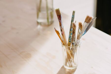 A brush in a glass on a light background backlit by the rays of the sun.の写真素材
