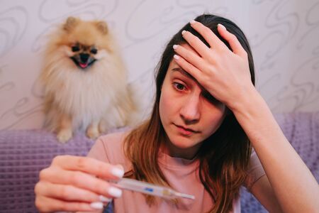 COVID-19 Coronavirus fever symptom woman checking high temperatureの写真素材