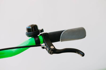 Close-up green bicycle handlebar made of metal and black bicycle bell and brakesの写真素材