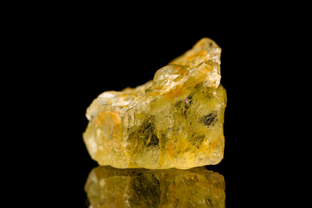 Closeup natural rough golden beryl (beryl group) gemstone on dark background (selective focus)の写真素材
