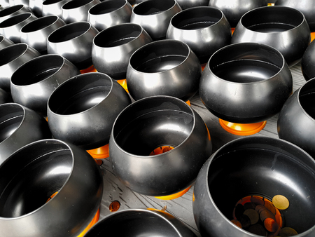 Thai coin in a little monk's bowl (alms bowl) for make a wish or exorcise from believe in Buddhism at temple Thailandの写真素材