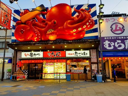 OSAKA, JAPAN - MAR 26 2018 : The Shinsekai market is the famous night street with restaurant and retail stores and landmark Tsutenkaku Tower in Osaka.のeditorial素材