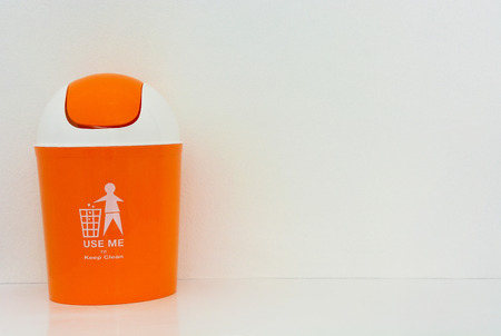 orange bin with text on white background, copy space