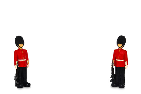 two Queen's guard statue in traditional uniform with weapon, British soldier for background,...