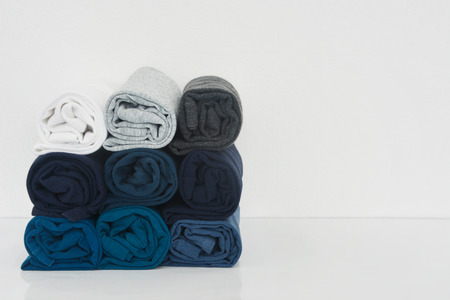 stack of t-shirt rolled up on white background, copy spaceの写真素材