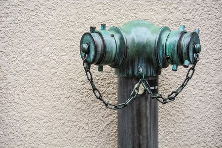 old vintage green fire hydrant in Tokyo, Japan for emergency fire access on rough concrete wall texture background, copy spaceの写真素材