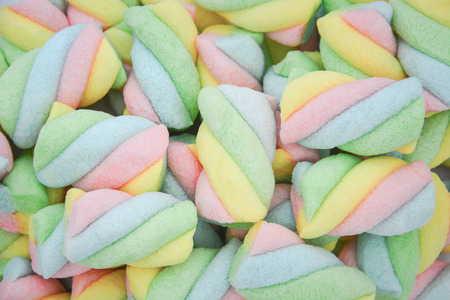 top view pile of twisted pastel color marshmallow on white background