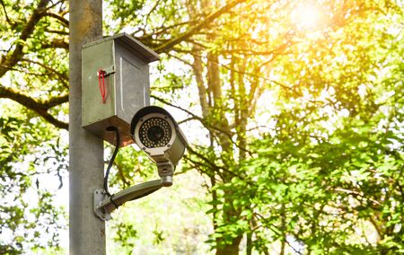 old white CCTV camera or surveillance on the pole for monitoring in public park