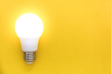 LED light bulb on yellow background, concept of ideas, creativity, innovation or saving energy, copy...