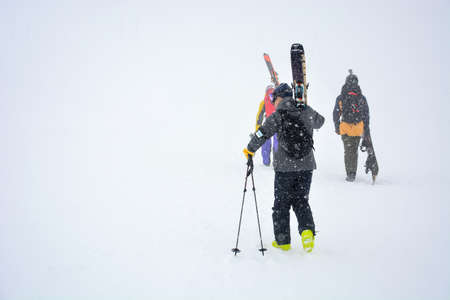 Hokkaido, Japan - March 3, 2018 : male skier carries skis and equipment to the track on a slope for...