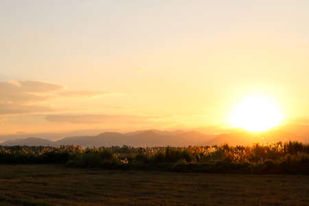 The sun setting down behind the mountain.の写真素材