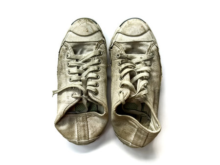The white sneaker is very dirty on white background.