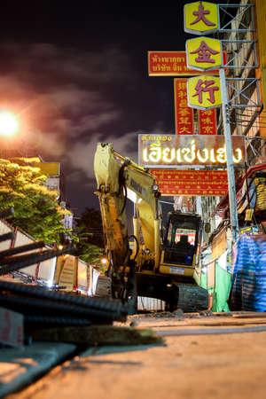 Bangkok, Thailand - September 17, 2016 : Excavator machine is parking on subway construction site in Yaowarat chinatown at night.のeditorial素材