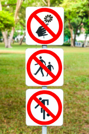 Signs do not pick flowers, do not step on grass and not play football in the park.の写真素材
