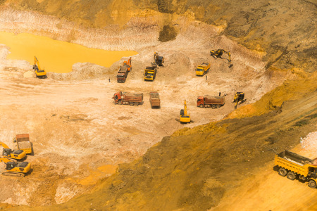 Wheel loader Excavator unloading sand, tractors and dump truck inside construction siteの写真素材