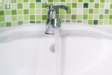 white sink washbasin and silver faucet with green tileの写真素材