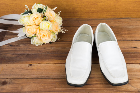 Wedding bouquet with groom's shoes on wood floor backgroundの写真素材