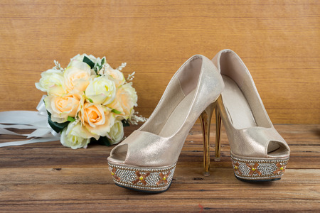 Wedding bouquet with bride's shoes on wood floor backgroundの写真素材