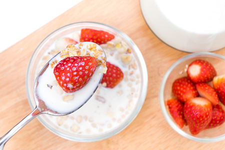 Breakfast, eating cereal, pick up spoon, scoop cereal with strawberries, ready to eat , Top shotの写真素材