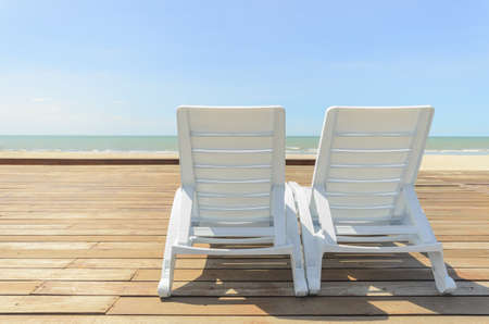 white chaise longue place on woodden floor at the sea viewの写真素材