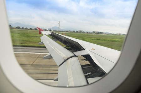 the wing is moving up when airplane is landing to runwayの写真素材