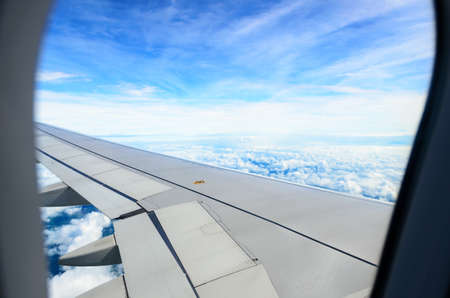 looking the sky view through airplane window with window frameの写真素材