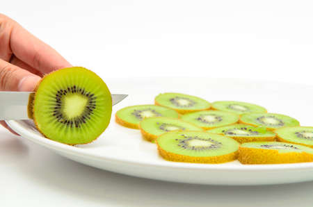 cutting kiwi fruits isolated on the white の写真素材