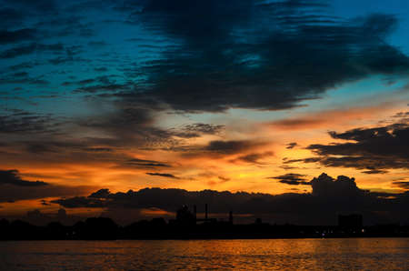twilight sunset scene and the silhouette manufactory near riverの写真素材