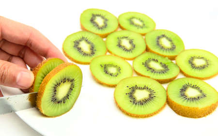 hand slicing kiwi fruits isolated on the white の写真素材