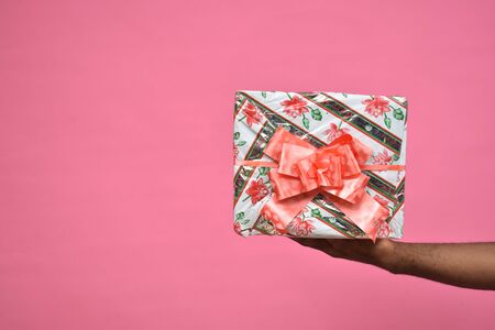 stretched hand holding a gift box