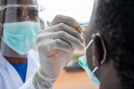 young black lab scientist taking nasal sample from a patient