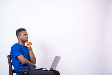 young african man thinking about something while using his laptop