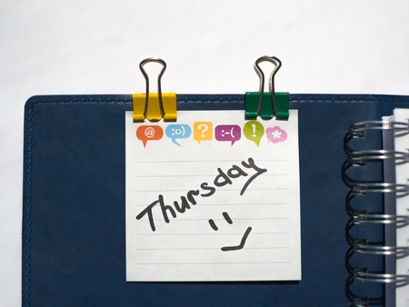 the name of the day of the week written on a sticky sheet in a blue notebook with springs
