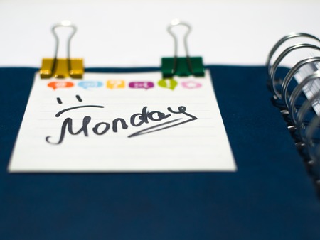 the name of the day of the week written on a sticky sheet in a blue notebook with metal springsの写真素材