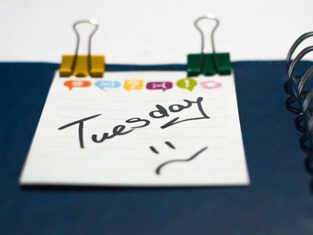 the name of the day of the week written on a sticky sheet in a blue notebook with metal springsの写真素材