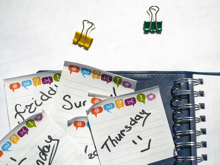 the name of the day of the week written on a sticky sheet in a blue notebook with metal springsの写真素材
