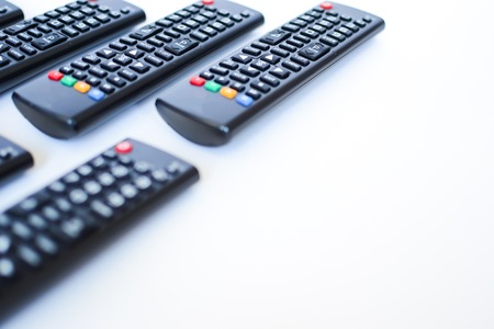 especially heavily blurred black remote controls for the TV on a white background, closeupの写真素材