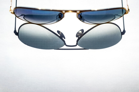 isolated shade from blue sunglasses with Golden frame on white paper sheetの写真素材