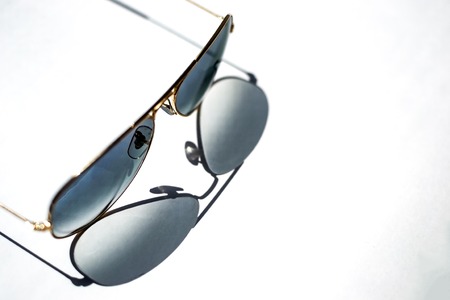 isolated shade from blue sunglasses with Golden frame on white paper sheetの写真素材