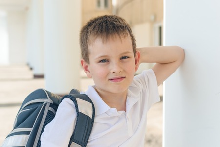 the boy is a first-grader in a white t-shirt with a gray backpack. different emotions. back to schoolの写真素材