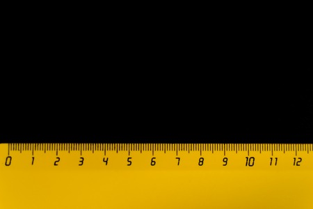 yellow ruler on a black background 12 centimeters.の写真素材