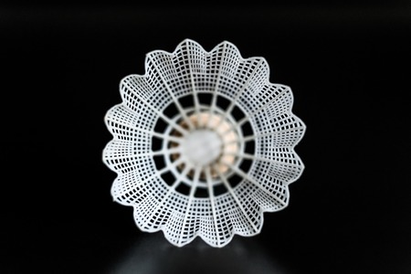 white shuttlecock in the center close-up on black background.の写真素材